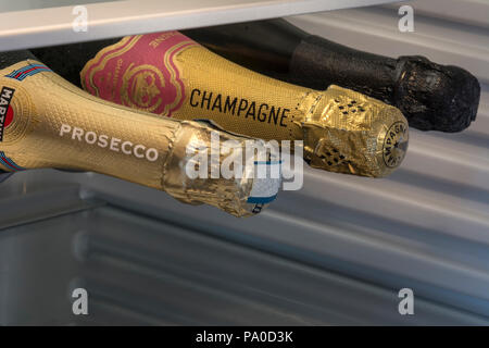 Prosecco and Champagne including Dom Perignon sparkling wine bottles stored horizontally in chilled temperature controlled wine cabinet refrigerator Stock Photo