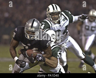 Oakland, California, USA. 2nd Dec, 2002. New York Jets linebacker James Darling (51) and defensive back Ray Mickens (24) tackle Oakland Raiders wide receiver Jerry Porter (84) on Monday, December 2, 2002, in Oakland, California. The Raiders defeated the Jets 26-20. Credit: Al Golub/ZUMA Wire/Alamy Live News Stock Photo