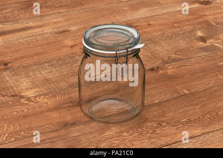 Empty glass jar with clamp lid. Isolated on wooden background with clipping path around jar Stock Photo