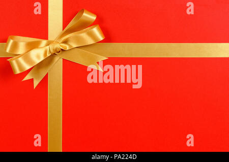 Gold bow gift ribbon red background Stock Photo