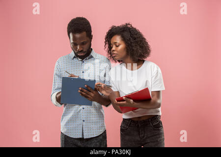 Two african students with folders in t-shirts together. Stylish girl with Afro hairstyle and her boyfriend. Stock Photo