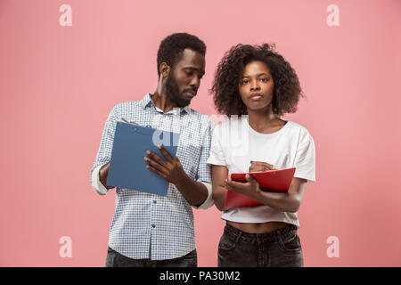 Two african students with folders in t-shirts together. Stylish girl with Afro hairstyle and her boyfriend. Stock Photo