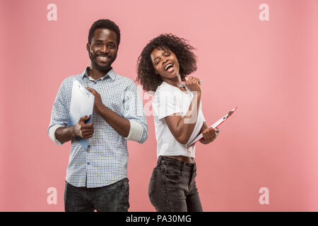 Two african students with folders in t-shirts together. Stylish girl with Afro hairstyle and her boyfriend. Stock Photo