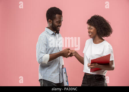 Two african students with folders in t-shirts together. Stylish girl with Afro hairstyle and her boyfriend. Stock Photo