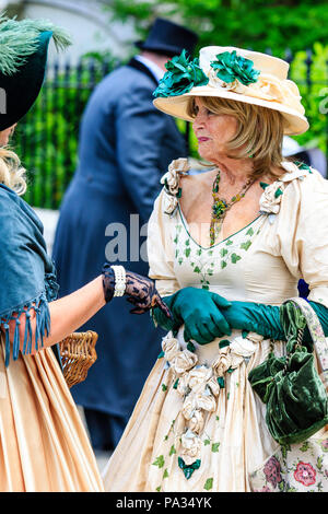 Caucasian blonde women, 60s, dressed up in Victorian dress during the Broadstairs Dickens week festival. Standing listening to another women. Stock Photo