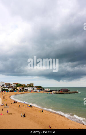 Broadstairs Viking Bay beach, Bleak House and harbour with few people on beach. Sky overcast, very grey, storm clouds gathering. Yachts at sea. Stock Photo
