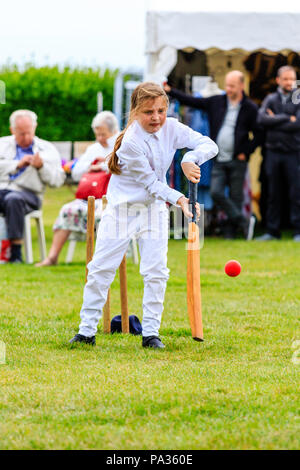 Young girl, child, 12-13 years, batting with cricket bat while dressed up in Victorian costume during cricket match. Broadstairs Dickens week festival Stock Photo