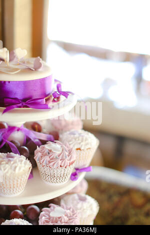 Violet decorations and sweet cakes for party. Stock Photo