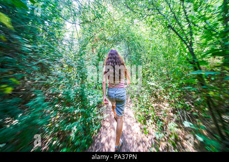 Woman running through a forest in Pfaffenhofen a.d.Ilm, Germany July 20, 2018 © Peter Schatz / Alamy Stock Photo Stock Photo