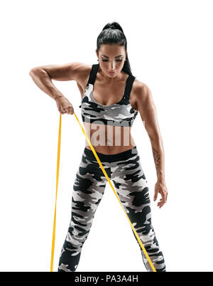 Woman with beautiful athletic body performs exercises using a resistance band. Photo of latin woman in military sportswear isolated on white backgroun Stock Photo