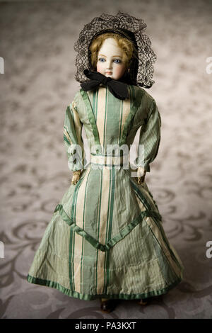 English: French fashion bisque doll, wearing a green and white striped dress. Title: French Fashion Bisque Doll with Green and White Striped Dress . between 1870 and 1880 676 French Fashion