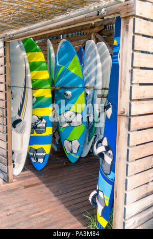 Set of different color surf boards in a stack for rent in Lefkada, Greece Stock Photo