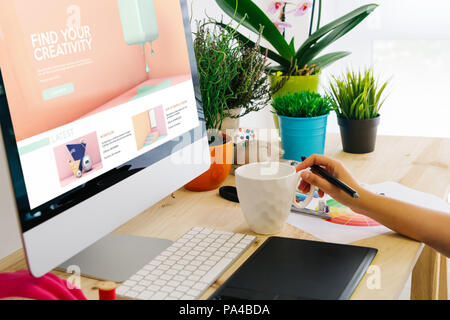 Graphic designer using pen tablet to learn graphic design. All screen graphics are made up. Stock Photo