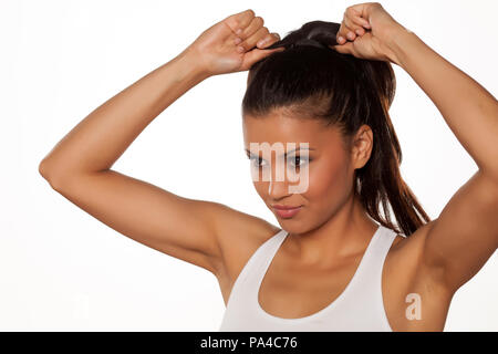 young beautiful woman adjusts her pony tail Stock Photo