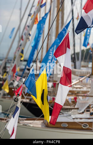 flags and bunting on yachts in the marina or yacht haven at cowes on the isle of wight during cowes week regatta. Stock Photo