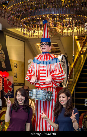 OSAKA, JAPAN - OCTOBER 9, 2016: Unidentified women by Kuidaore Taro mechanicl drum playing clown at Dotonbori in Osaka, Japan. It is an Osaka symbol i Stock Photo