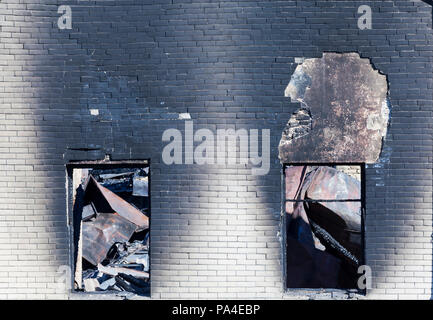 two windows and part of the wall of the brick building after the fire, closeup at the site of the disaster Stock Photo