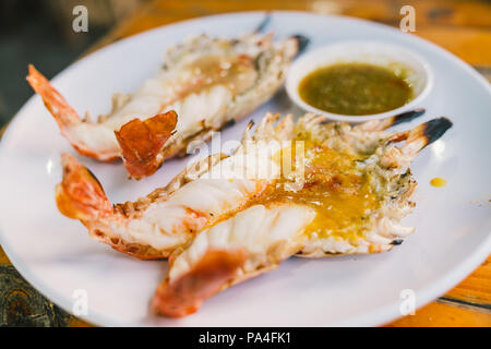 Two grilled giant freshwater river prawns jumbo sized, served with Thai spicy seafood sauce, Thailand famous delicious menu. Asian exotic food concept Stock Photo