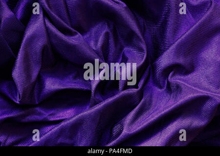 Closeup ultra violet macro texture of shiny smooth material fabric, clothing background with wrinkles and folds Stock Photo