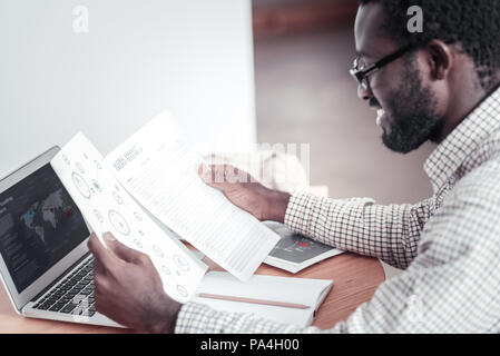 Delighted professional man working on his project Stock Photo