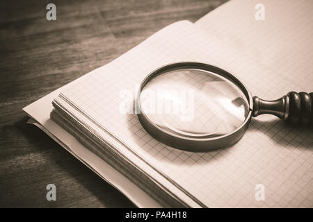 Vintage Magnifier Lying On An Open Quad-Ruled Organizer In Sepia Colors Stock Photo