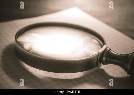 Vintage Loupe Lying On An Open Checkered Diary In Sepia Colors Stock Photo