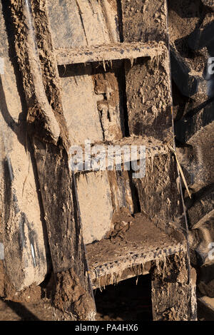 metal ladder on a tractor or other agricultural machinery, completely dirty and covered with a thick layer of mud, closeup Stock Photo
