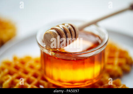 Honey in a jar with wooden dipper Stock Photo