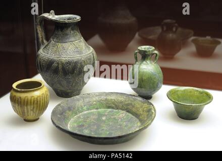Set of Roman ceramic objects in green and yellow. From Cologne (Luxembourg and Aachener streets) and unknown origin. Roman-Germanic Museum. Cologne. Germany. Stock Photo