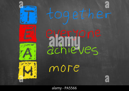 Together everyone achieves more colorful team chalk text on chalkboard or blackboard as teamwork cooperation motivation business concept Stock Photo