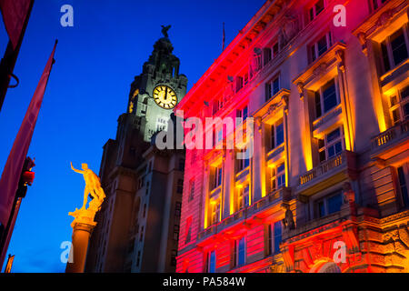 Night Time shot of the Port of Liverpool Building illuminated in red and orange lights, with the Royal Liver Building in the background Stock Photo