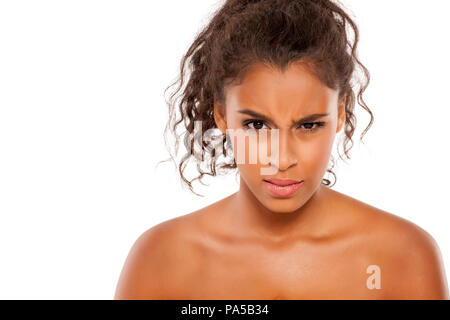 Portrait of a beautiful young dark-skinned scowling woman on a white background Stock Photo