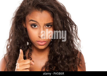 Nervous and angry dark skinned young girl on white background Stock Photo