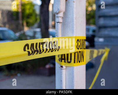 Close up of caution yellow trap hanging on a pole and blocking a path  Stock Photo