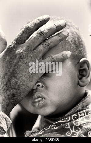 KENYA - OCTOBER 10, 2009: Unidentified Massai woman touches her baby's face in Kenya, Oct 10, 2009. Massai people are a Nilotic ethnic group Stock Photo