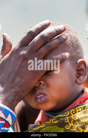 AMBOSELI, KENYA - OCTOBER 10, 2009: Unidentified Massai woman touches her baby's face in Kenya, Oct 10, 2009. Massai people are a Nilotic ethnic group Stock Photo