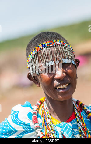 AMBOSELI, KENYA - OCTOBER 10, 2009: Unidentified Massai woman walks wearing typical tribal clothes in Kenya, Oct 10, 2009. Massai people are a Nilotic Stock Photo