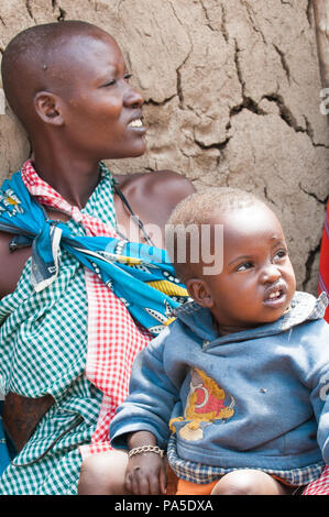 AMBOSELI, KENYA - OCTOBER 10, 2009: Unidentified Massai woman holds her litle baby on her knees in Kenya, Oct 10, 2009. Massai people are a Nilotic et Stock Photo