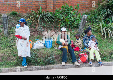 ANTANANARIVO, MADAGASCAR - JUNE 29, 2011: Unidentified Madagascar mothers with their children sitting on the ground.  People in Madagascar suffer of p Stock Photo