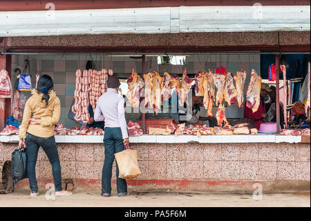 ANTANANARIVO, MADAGASCAR - JUNE 29, 2011: Unidentified Madagascar man chooses meat and sausages at the market. People in Madagascar suffer of poverty  Stock Photo