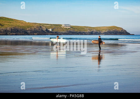 24 June 2018: Newquay, Cornwall, UK - Surfers carrying their boards on Fistral Beach. Stock Photo