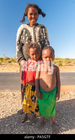 ANTANANARIVO, MADAGASCAR - JULY 3, 2011: Unidentified Madagascar woman and her children stay near the road. People in Madagascar suffer of poverty due Stock Photo
