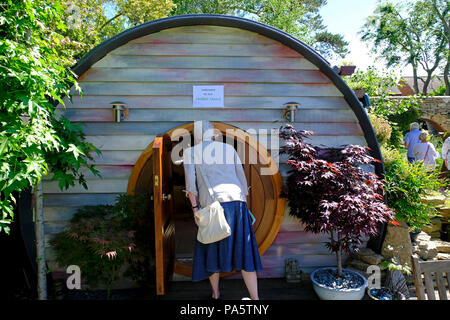 Lady peering into Hobbit House garden summerhouse Stock Photo