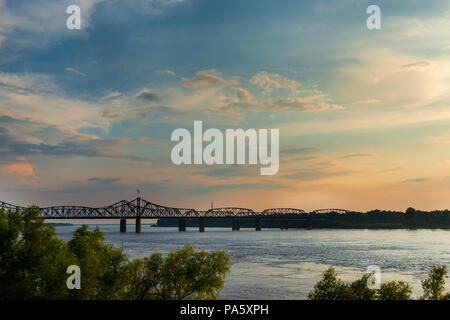 View of the Mississippi River with the Vicksburg Bridge on the background at sunset; Concept for travel in the USA and visit Mississippi Stock Photo