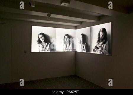 Inside interior of the Anne Frank House Museum in Amsterdam: Four panels showing different photos of Anne Frank in black and white Stock Photo