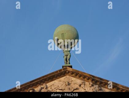 Statue of Atlas carrying the globe or world on his shoulders, on top of the Royal Palace of Amsterdam in Dam Square Stock Photo