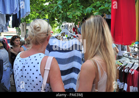 view from behind mum and daughter shop for clothes in a market. Model released Stock Photo