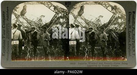 . English: Horizontal, sepia stereocard showing group of uniformed men surveying the wreckage of a zeppelin. Keystone Stereograph number 18632. The title reads: 'Zeppelin Wrecked and Burned - Ruins Being Inspected by French Troops.' Title: 'French Troops Inspecting a Wrecked Zeppelin.' . between circa 1914 and circa 1918 3 &quot;French Troops Inspecting a Wrecked Zeppelin.&quot; Stock Photo