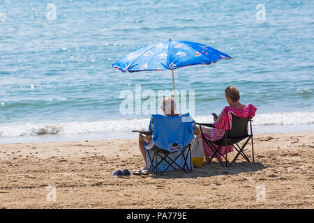 Bournemouth, Dorset, UK. 21st July 2018. UK weather: hot and sunny at Bournemouth beaches, as sunseekers head to the seaside to soak up the sun at the start of the summer holidays. mature couple relaxing in chairs under nautical themed parasol at the seashore on Bournemouth beach. Credit: Carolyn Jenkins/Alamy Live News Stock Photo