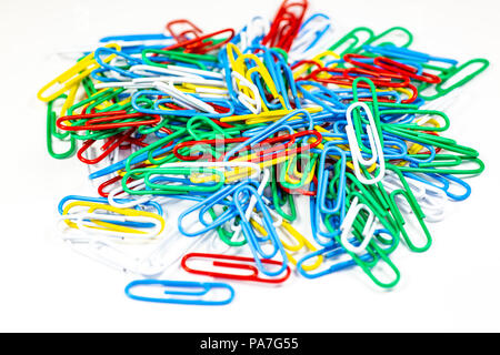Colorful paperclips bunched up on a white surface. Stock Photo